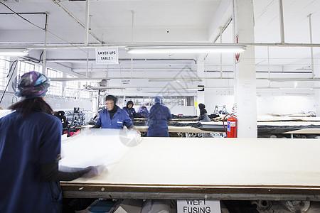 女工在服装厂展开纺织品图片素材